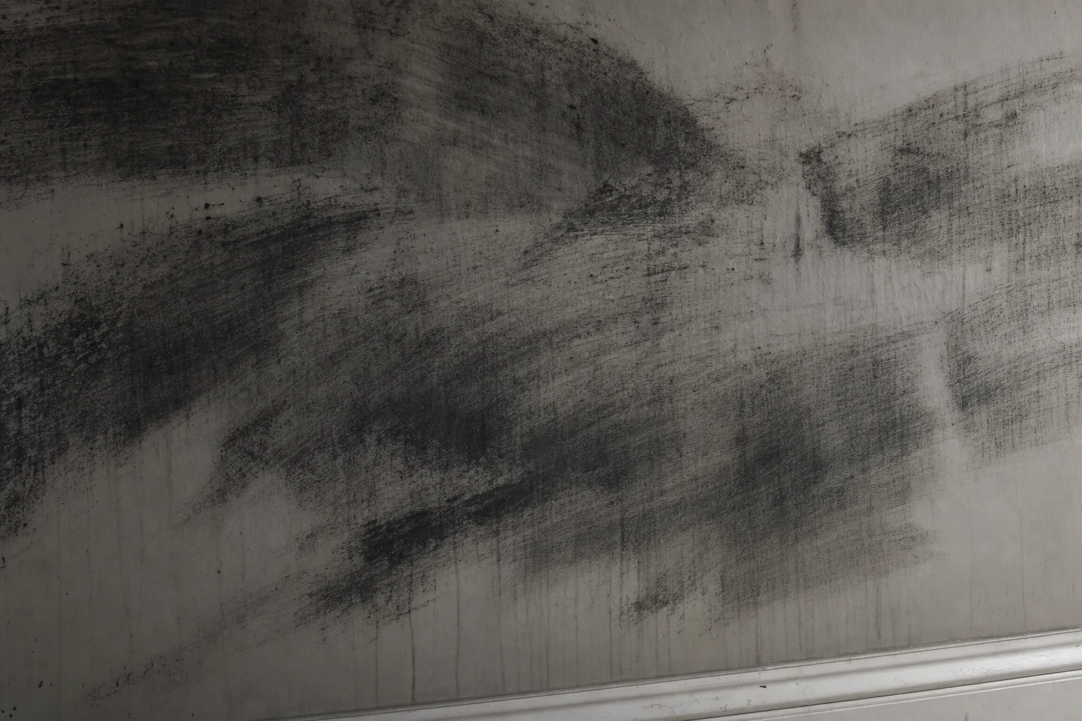 Soot streaked across a white wall by a household sponge in a Northern Virginia home